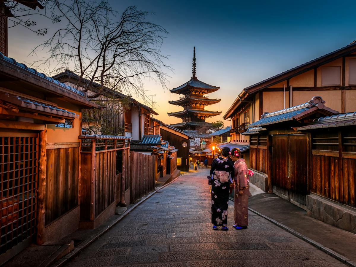 Calle tradicional de Kioto al atardecer con una pagoda al fondo