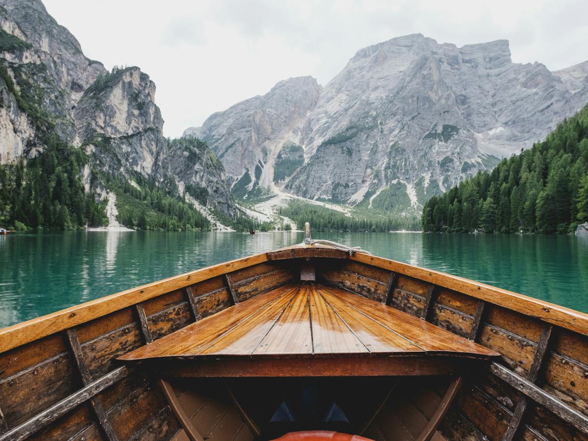Barca de madera cruzando un lago de montaña
